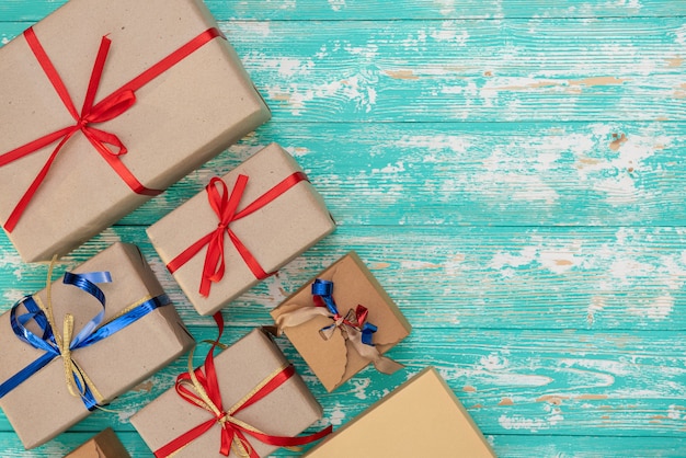 Foto gratuita fondo de compras de regalo de vacaciones de navidad. vista desde arriba con espacio de copia. cajas de regalo de papel artesanal atadas con cuerda sobre fondo azul, vista superior. composición plana para cumpleaños.