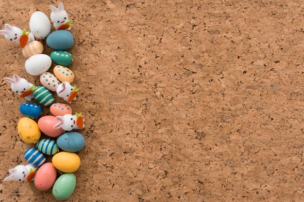 Fondo de corcho con huevos de pascua y conejos