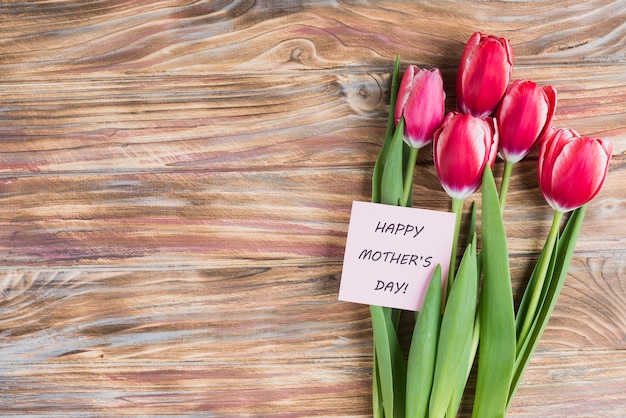 Fondo del día de la madre con tarjeta y tulipanes bonitos