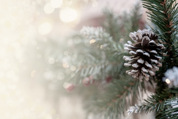 Fondo de efecto bokeh navideño con ramas de pino, conos y espacio para inscripción