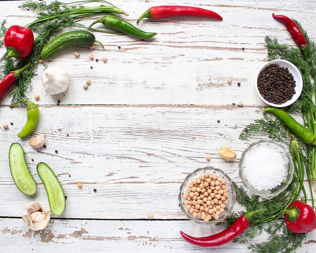 Fondo de encurtidos en la mesa de madera blanca con verde y rojo y chiles, hinojo, sal, granos de pimienta negra, ajo, guisantes, primer plano, concepto saludable, vista superior, endecha plana