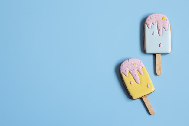 Fondo con galletas de jengibre festivas en forma de helado en un palo, cubierto con espacio de copia de esmalte.