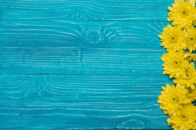 Fondo de madera azul con flores y espacio para mensajes