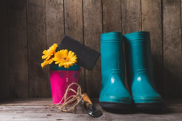 Fondo de madera con botas y artículos de jardinería