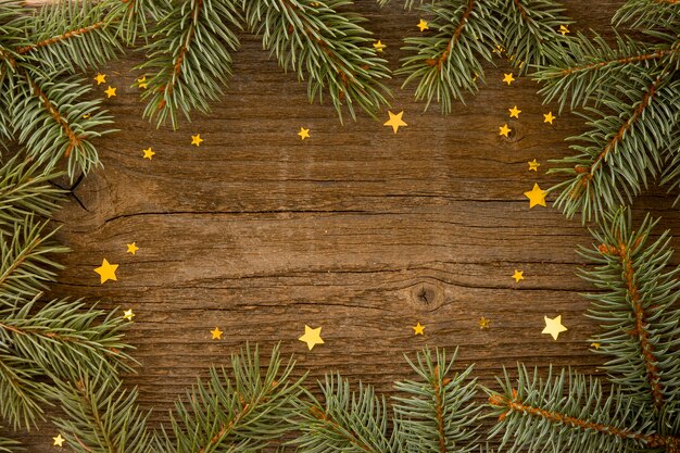 Fondo de madera con hojas de pino y estrellas