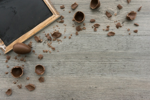 Fondo de madera con huevos de chocolate y pizarra