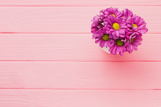 Fondo de madera rosa con flores moradas