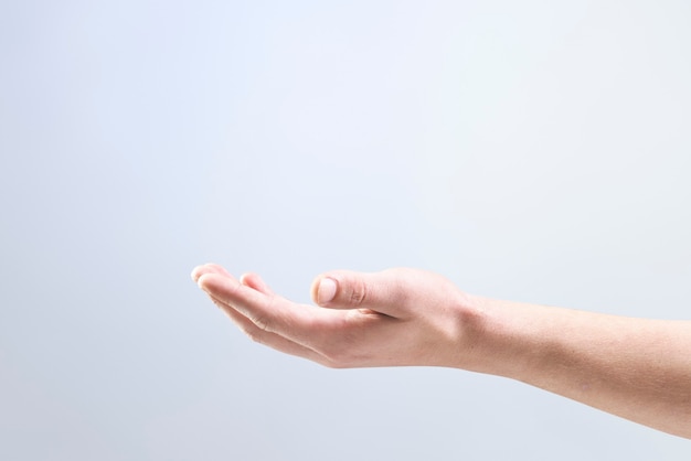 Foto gratuita fondo de mano de mujer mostrando gesto de objeto invisible