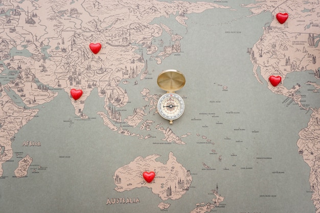 Fondo de mapa del mundo con brújula y corazones rojos
