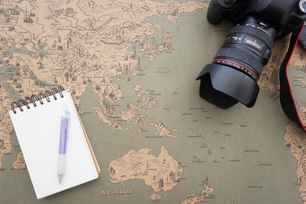 Foto gratuita fondo de mapa del mundo con cámara decorativa y cuaderno