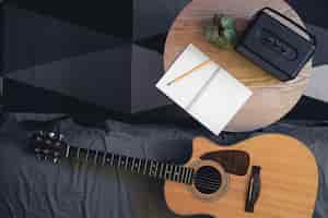 Foto gratuita fondo musical con altavoz de guitarra acústica y bloc de notas en la mesa