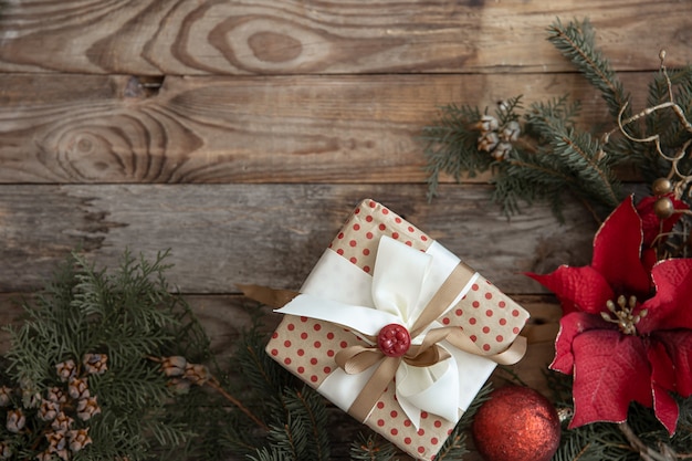 Fondo de navidad con flores de nochebuena y regalo de navidad plano lay