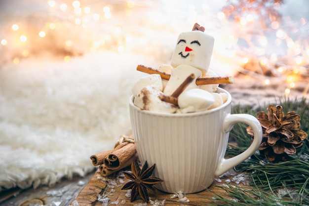 Fondo de navidad con muñeco de nieve de malvavisco en una taza