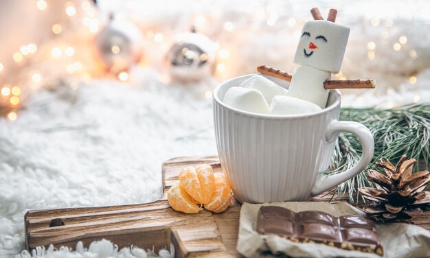 Fondo de navidad con muñeco de nieve de malvavisco en una taza