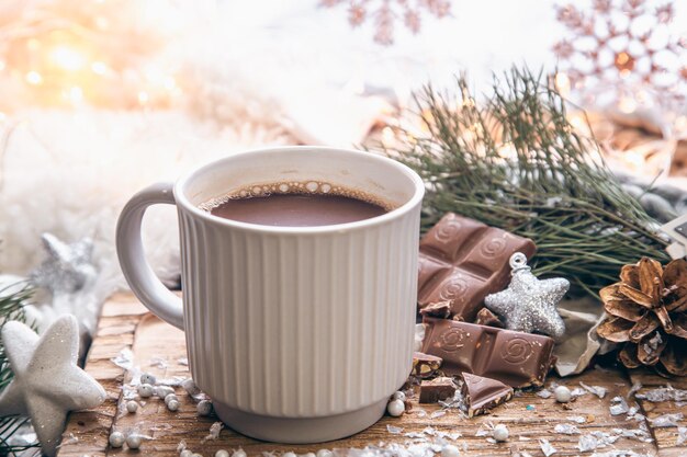 Fondo navideño con una taza de cacao y detalles de decoración festiva