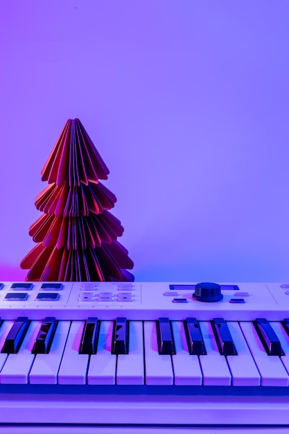 Foto gratuita fondo navideño con teclado midi y decoración navideña con luces de neón