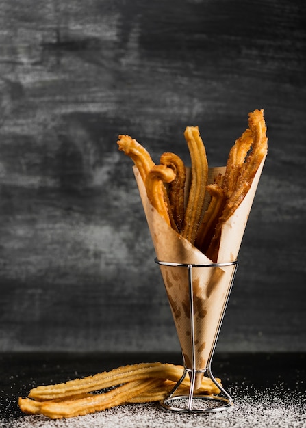 Foto gratuita fondo negro con churros en papel de regalo