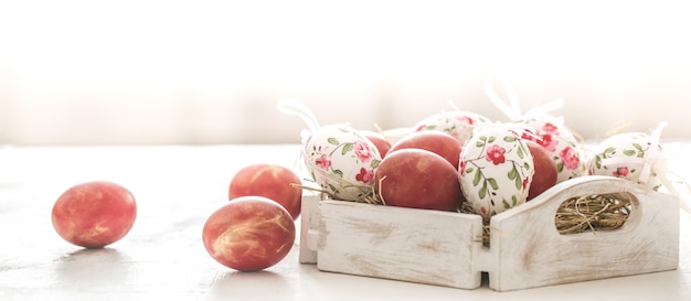 Fondo de Pascua con una canasta y huevos rojos con flores