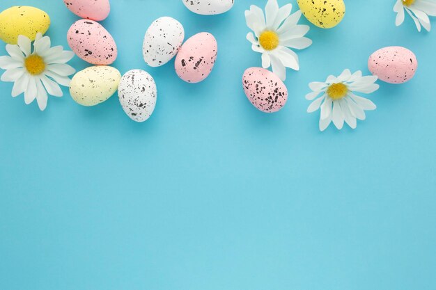 Fondo de Pascua con huevos y margaritas sobre un fondo azul con espacio de copia