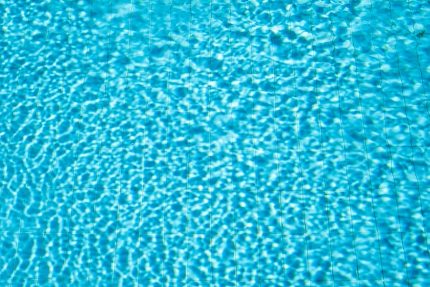 Fondo de piscina con agua a la luz del sol fondo de agua borrosa