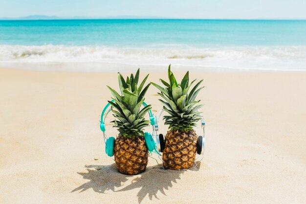 Fondo de playa con piñas con auriculares