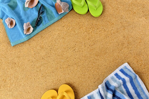 Fondo de playa con toallas y chanclas