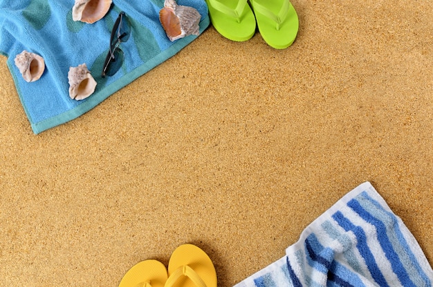 Fondo de playa con toallas y chanclas