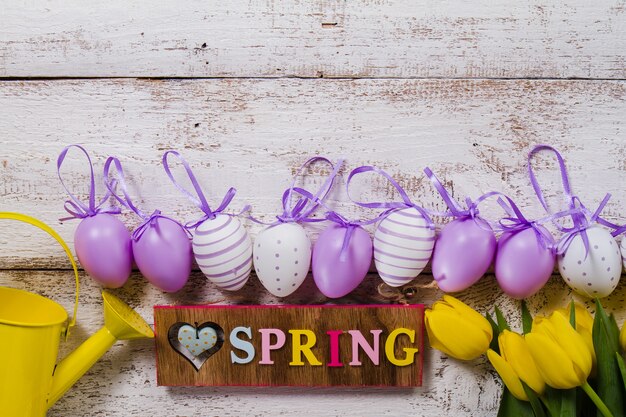 Fondo de primavera con flores y huevos de pascua en fila