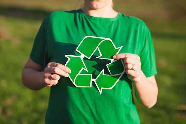 Fondo de reciclaje con mujer sujetando signo de reciclaje