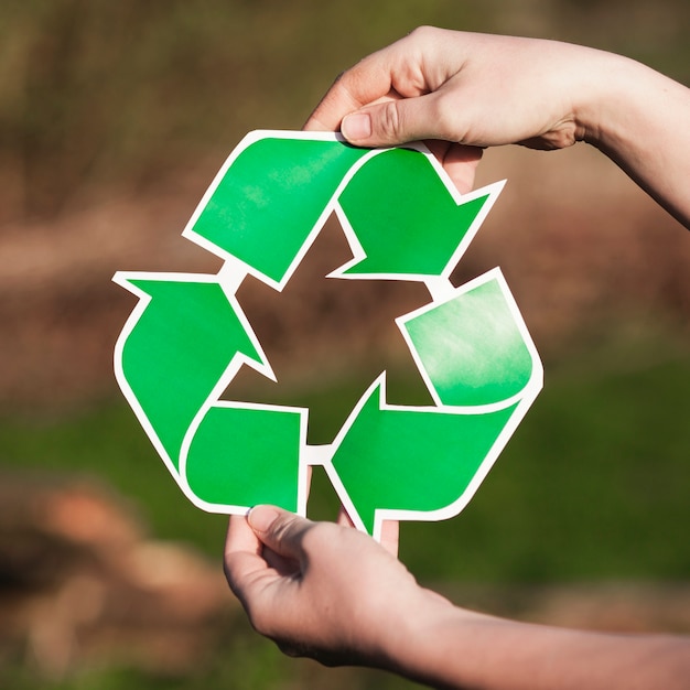 Fondo de reciclaje con mujer sujetando signo de reciclaje