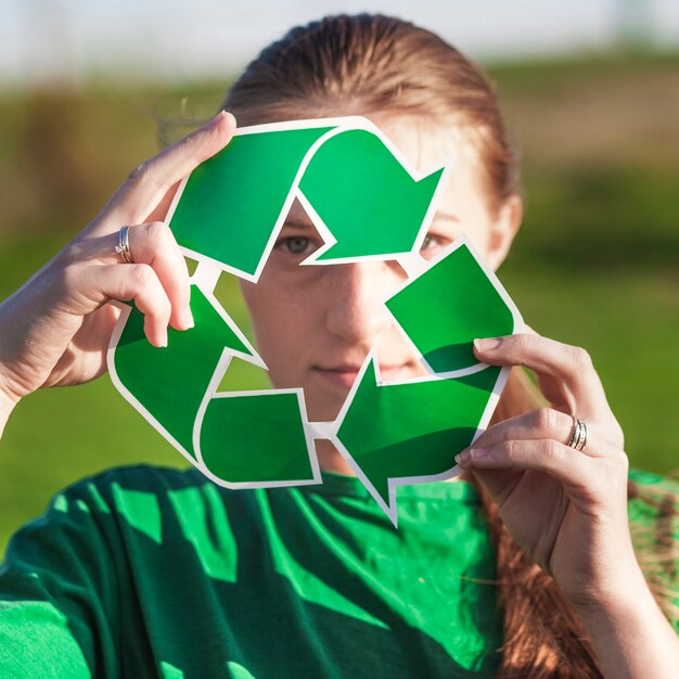 Fondo de reciclaje con mujer sujetando signo de reciclaje