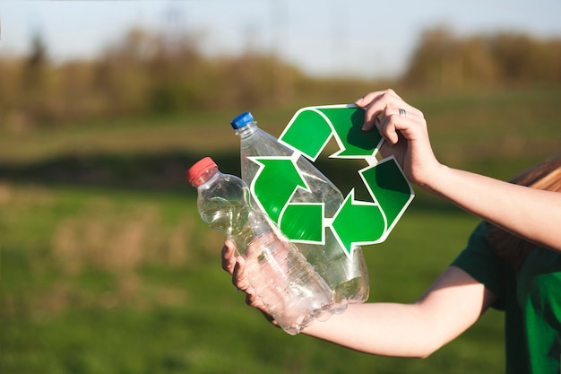 Fondo de reciclaje con mujer sujetando signo de reciclaje