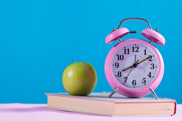 Fondo de regreso a la escuela con libros, Apple y despertador.