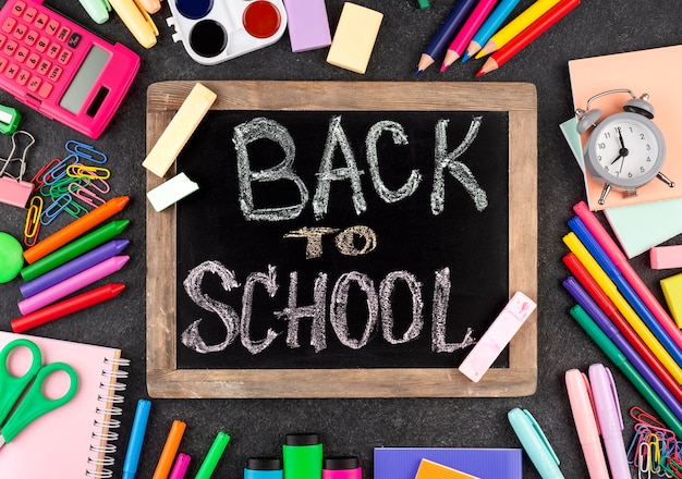 Fondo de regreso a la escuela con útiles escolares en pizarra