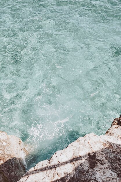 Fondo de rocas y aguas de la orilla del mar