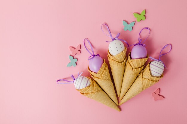 Fondo rosa con cucuruchos y huevos de pascua