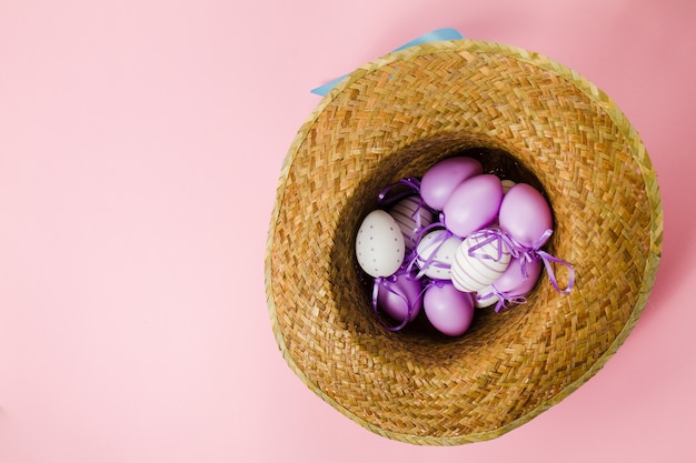 Fondo rosa con sombrero y huevos de pascua