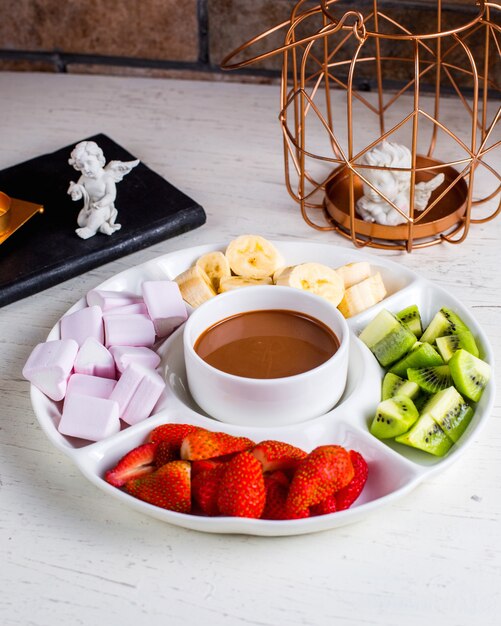 Fondue con frutas sobre la mesa