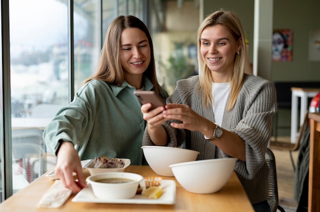 Foodie tomando una foto de un tazón con sopa