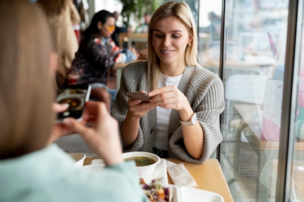 Foodie tomando una foto de un tazón con sopa