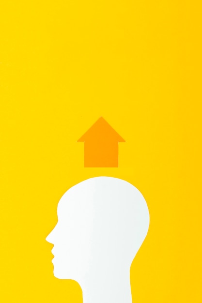 Forma de cabeza con flecha sobre fondo amarillo