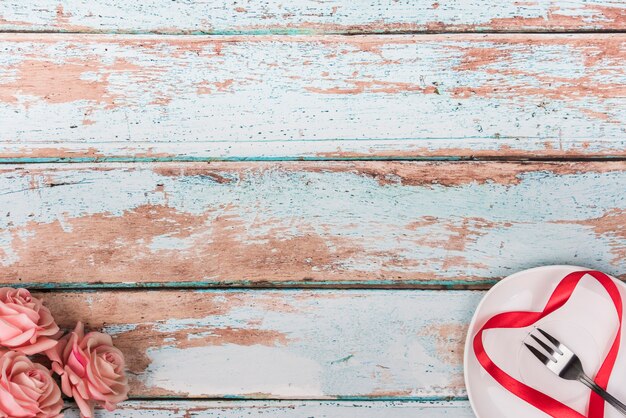 Forma de corazón de la cinta en el plato con rosas