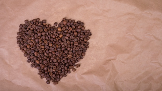 Foto gratuita forma de corazón de granos de café sobre papel