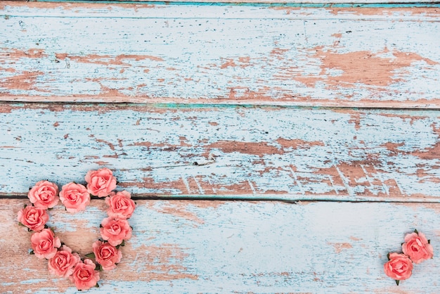 Forma de corazón hecha de capullos de rosas en la mesa