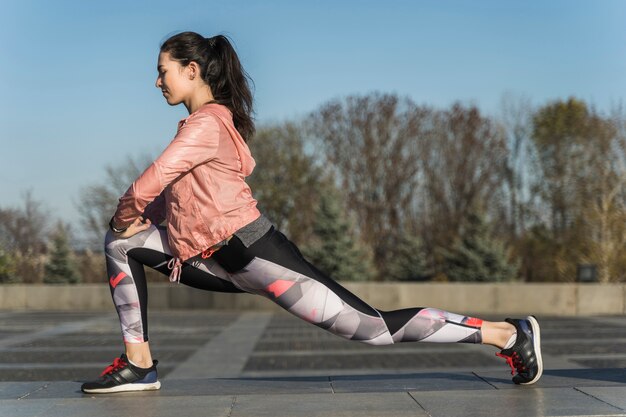 Forma joven estirando al aire libre