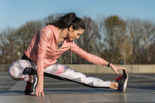 Forma joven estirando al aire libre