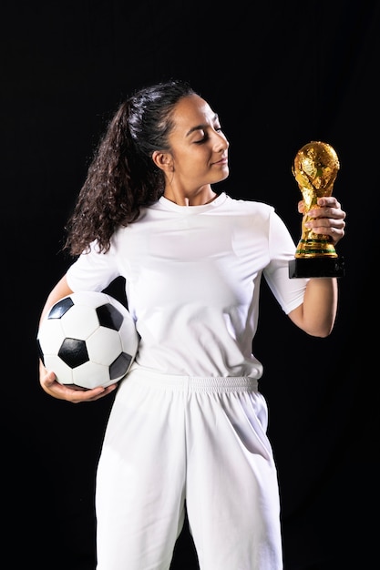 Foto gratuita forma joven sosteniendo trofeo y bola