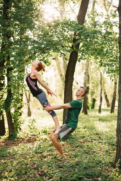 Forma pareja haciendo acroyoga equilibrio en el parque