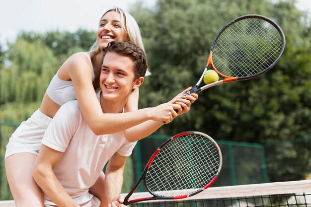 Forma pareja joven jugando tenis