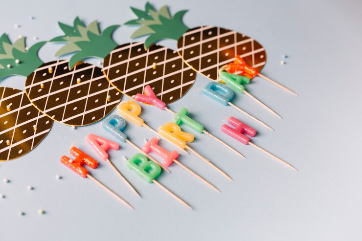 Foto gratuito la forma de la piña cortó con las velas coloridas del feliz cumpleaños en el fondo blanco